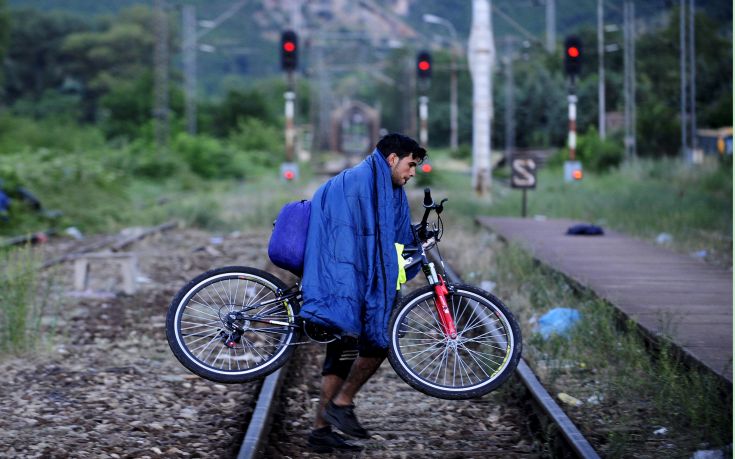 A migrant from Syria carries his bicycle on railway near the Greek border in Macedonia  June 17, 2015.  Hungary announced plans on Wednesday to build a four-metre-high fence along its border with Serbia to stem the flow of illegal migrants. Several thousand migrants are daily crossing the Balkans towards Hungary on their way to other European Union countries. REUTERS/Ognen Teofilovski
