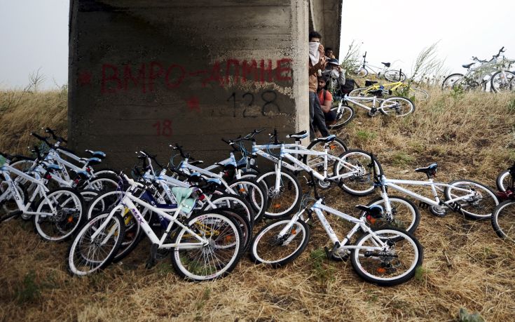 Immigrants from Syria stand near their bicycles as they hide from the rain under a bridge near the Greek border with Macedonia,  June 17, 2015. Hungary announced plans on Wednesday to build a four-metre-high fence along its border with Serbia to stem the flow of illegal migrants. Several thousand migrants are daily crossing the Balkans towards Hungary on their way to other European Union countries.  REUTERS/Ognen Teofilovski       TPX IMAGES OF THE DAY