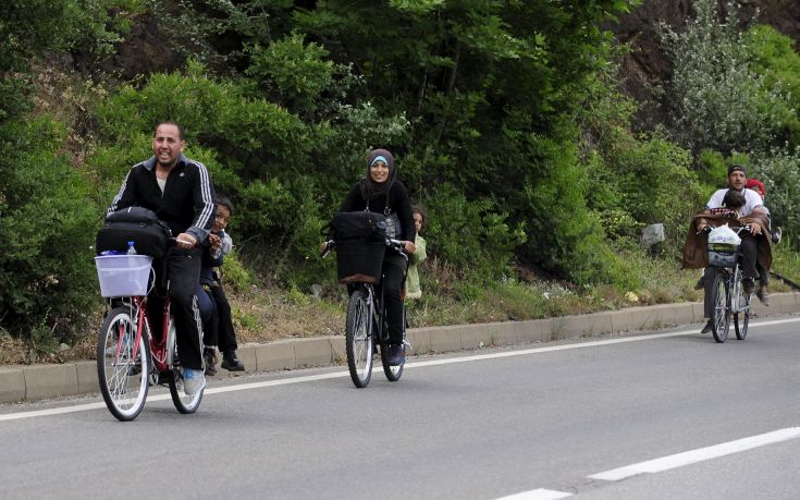 Migrants from Syria ride their bicycles near the Greek border in Macedonia June 17, 2015.  Hungary announced plans on Wednesday to build a four-metre-high fence along its border with Serbia to stem the flow of illegal migrants. Tens of thousands of migrants enter Europe through the Balkans from the Middle East and Africa. REUTERS/Ognen Teofilovski