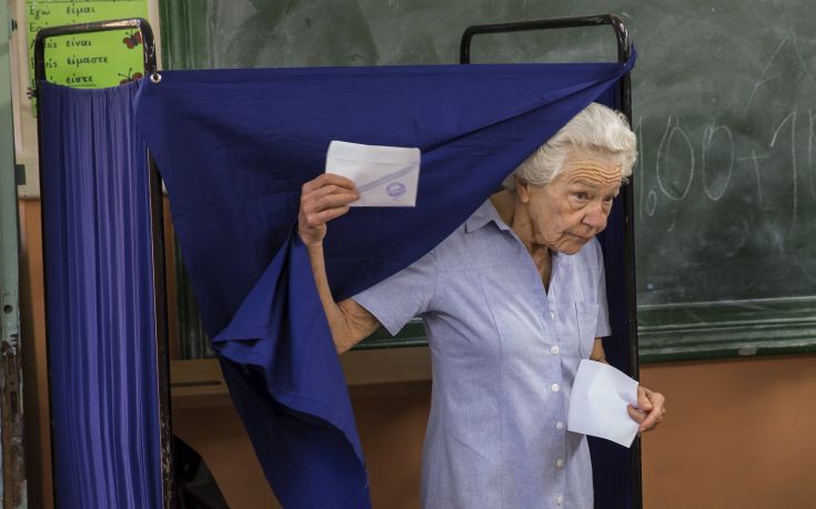 Woman leaves a polling booth to cast her ballot during a referendum vote in Athens