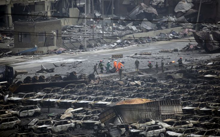 Firefighters walk among debris as they carry out the body of a victim from the site of the explosions towards an ambulance at the Binhai new district, Tianjin, China, August 14, 2015. Several Japanese automakers including Toyota Motor Corp reported damage to cars and facilities after two huge explosions at the Chinese port of Tianjin tore through an industrial area where toxic chemicals and gas were stored. REUTERS/Jason Lee