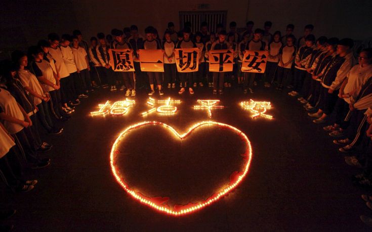 Students and teachers stand around lighted candles which form into Chinese characters "Tanggu be safe" and a heart shape, during a candlelight vigil for victims of the explosions in Tianjin on Wednesday night, at a school in Zhuji, Zhejiang province, China, August 13, 2015. The blasts at Tanggu of Binhai new district in Tianjin killed at least 50 people, including a dozen fire fighters, state media said. About 700 people were injured, 71 seriously. Chinese characters on the papers read, "hope all is safe". Picture taken August 13, 2015. REUTERS/Stringer CHINA OUT. NO COMMERCIAL OR EDITORIAL SALES IN CHINA         TPX IMAGES OF THE DAY