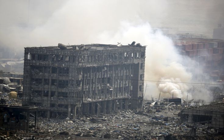 Smoke rises next to a damaged building at the site of the explosions at the Binhai new district in Tianjin, China, August 14, 2015. Investigators searched for clues on Friday to identify what caused two huge explosions at a warehouse storing volatile chemicals at a busy port in northeast China, as foreign and local companies assessed the damage to their operations. REUTERS/Jason Lee TPX IMAGES OF THE DAY