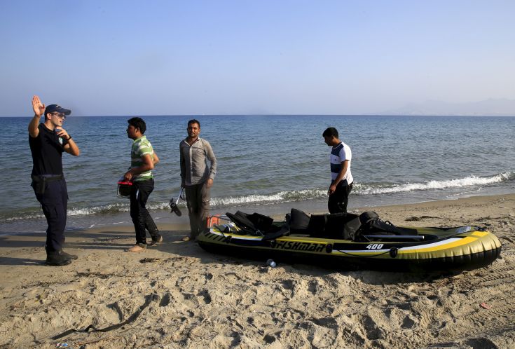 Greek coast guard officer briefs Afghan migrants who arrived moments ago on the Greek island of Kos after paddling across a part of the Aegean Sea between Turkey and Greece on, August 8, 2015. The U.N refugee agency, UNHCR, estimates that Greece has received more than 107,000 refugees and migrants this year, more than double its 43,500 intake of 2014. REUTERS/ Yannis Behrakis