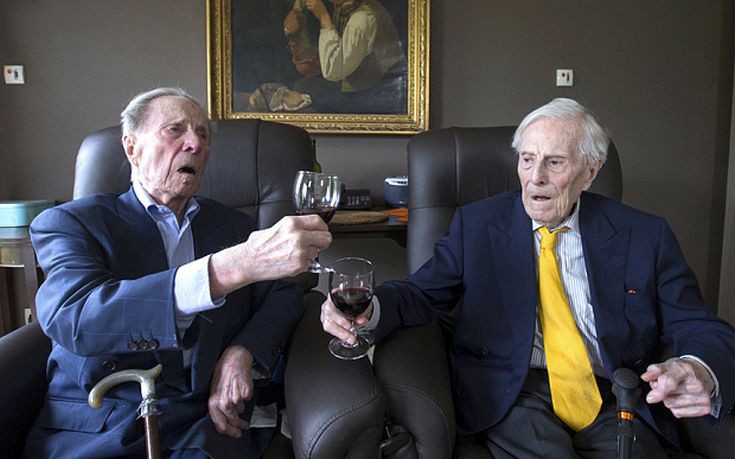 The world's oldest living twin brothers, Paulus (L) and Pieter Langerock from Belgium, 102, toast while sitting in their living room at the Ter Venne care home in Sint-Martens-Latem, Belgium, August 11, 2015. Born on July 8 1913, they never married and until this day sleep side by side in the same room. Eating in moderation, drinking a glass of good wine every day and avoiding chasing women are the secrets of a long life, Belgians Pieter and Paulus Langerock, the world's oldest living twin brothers, say. The brothers have lived together for most of their lives and until this day barely leave each other's side, sharing a room at their nursing home just outside the Belgian town of Ghent. Picture taken August 11, 2015. REUTERS/Yves Herman TPX IMAGES OF THE DAY