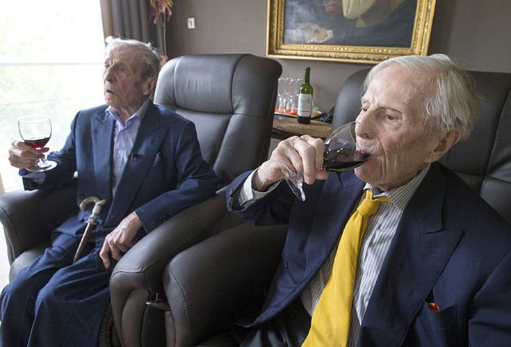 The world's oldest living twin brothers, Paulus (L) and Pieter Langerock from Belgium, 102, drink wine while sitting in their living room at the Ter Venne care home in Sint-Martens-Latem, Belgium, August 11, 2015. Born on July 8 1913, they never married and until this day sleep side by side in the same room. Eating in moderation, drinking a glass of good wine every day and avoiding chasing women are the secrets of a long life, Belgians Pieter and Paulus Langerock, the world's oldest living twin brothers, say. The brothers have lived together for most of their lives and until this day barely leave each other's side, sharing a room at their nursing home just outside the Belgian town of Ghent. Picture taken August 11, 2015. REUTERS/Yves Herman TPX IMAGES OF THE DAY