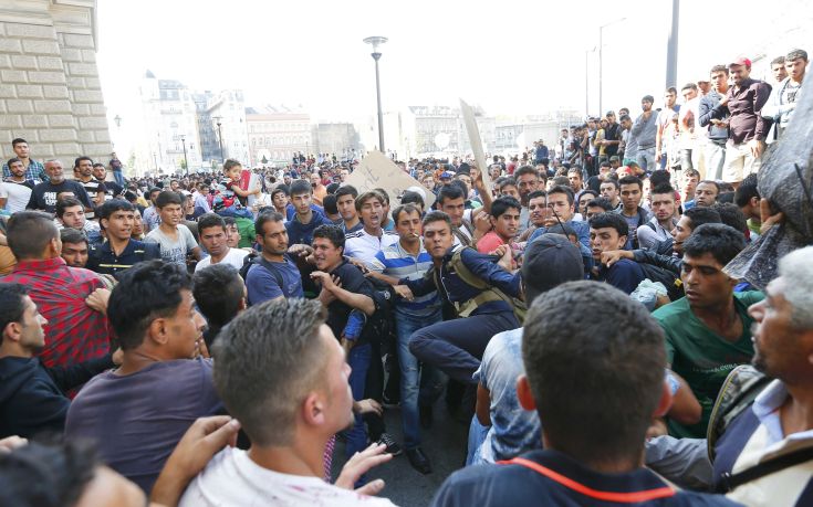 A group of migrants fights with others trying to make their way through the crowd to the Eastern railway station in Budapest