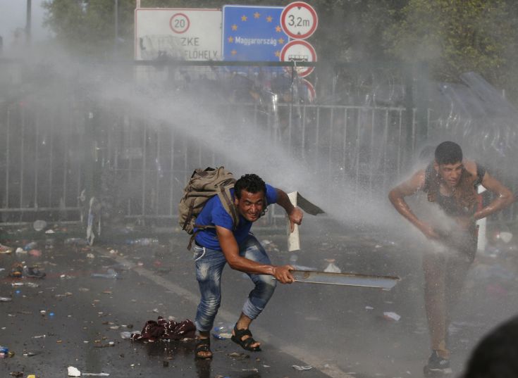 Hungarian riot police uses a water cannon against protesting migrants on the Serbian side of the border, near Roszke, Hungary September 16, 2015. Hungarian police fired tear gas and water cannon at protesting migrants demanding they be allowed to enter from Serbia on Wednesday on the second day of a border crackdown. REUTERS/Marko Djurica