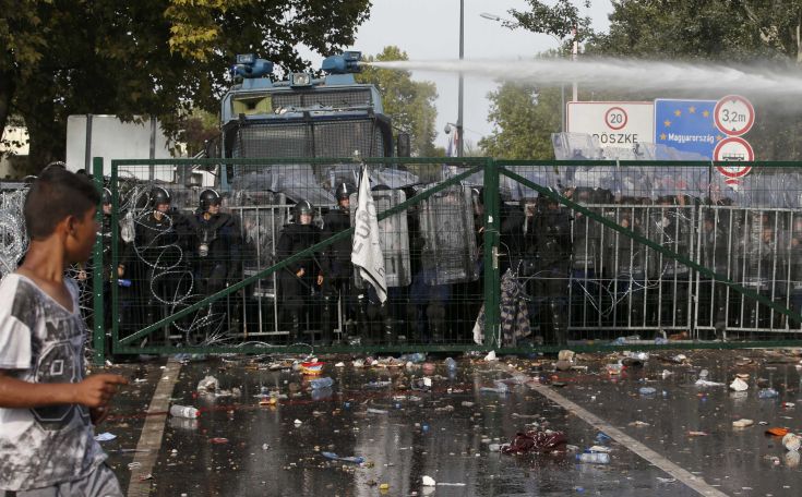 Hungarian riot police uses a water cannon against protesting migrants on the Serbian side of the border, near Roszke, Hungary September 16, 2015. Hungarian police fired tear gas and water cannon at protesting migrants demanding they be allowed to enter from Serbia on Wednesday on the second day of a border crackdown. REUTERS/Marko Djurica