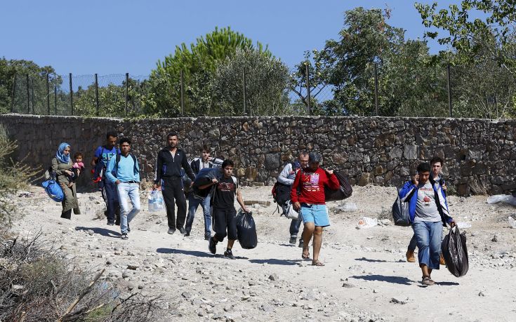 Syrian migrants walk to the shore to board a dinghy bound for the Greek island of Lesbos, in the Turkish coastal town of Behramkale