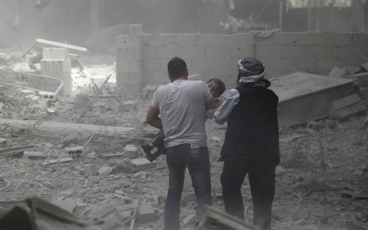 Men help an injured boy who survived what activists said were airstrikes by forces loyal to Syria's President Bashar al-Assad, in the Douma neighborhood of Damascus