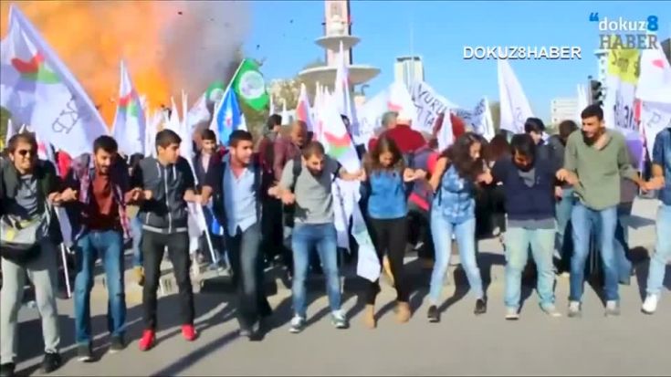 Protesters dance during a peace rally as a blast goes off in Ankara, Turkey October 10, 2015, in this still image taken from a video posted on a social media website. At least 30 people were killed when twin explosions hit a rally of pro-Kurdish and leftist activists outside Ankara's main train station on Saturday in what Turkish President Tayyip Erdogan called a terrorist attack, weeks ahead of an election. REUTERS/Melike Tombalak/dokuz8HABER via Reuters TVATTENTION EDITORS - THIS PICTURE WAS PROVIDED BY A THIRD PARTY. REUTERS IS UNABLE TO INDEPENDENTLY VERIFY THE AUTHENTICITY, CONTENT, LOCATION OR DATE OF THIS IMAGE. FOR EDITORIAL USE ONLY. NOT FOR SALE FOR MARKETING OR ADVERTISING CAMPAIGNS. NO SALES. THIS PICTURE IS DISTRIBUTED EXACTLY AS RECEIVED BY REUTERS, AS A SERVICE TO CLIENTS. TURKEY OUT. NO COMMERCIAL OR EDITORIAL SALES IN TURKEY TPX IMAGES OF THE DAY