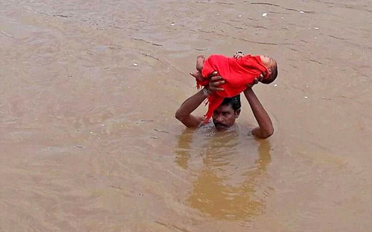 Πατέρας κουβαλάει το άρρωστο μωρό του μέσα στις πλημμύρες για δύο ώρες