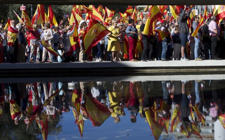 Spaniards pack Colon Square in Madrid, Spain, Saturday, Oct. 7, 2017. Thousands of pro-Spanish unity supporters donning Spanish flags have rallied in a central Madrid plaza to protest the Catalan regional government's drive to separate from Spain. (AP Photo/Paul White)