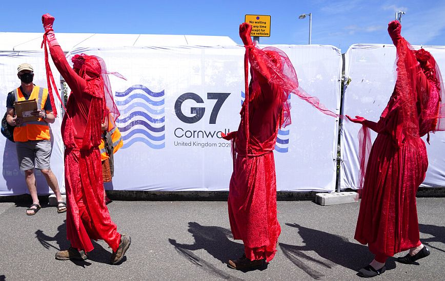 G7: Διαδηλωτές με μάσκες και κόκκινα ρούχα ζητούν άμεση δράση των ηγετών για το Κλίμα
