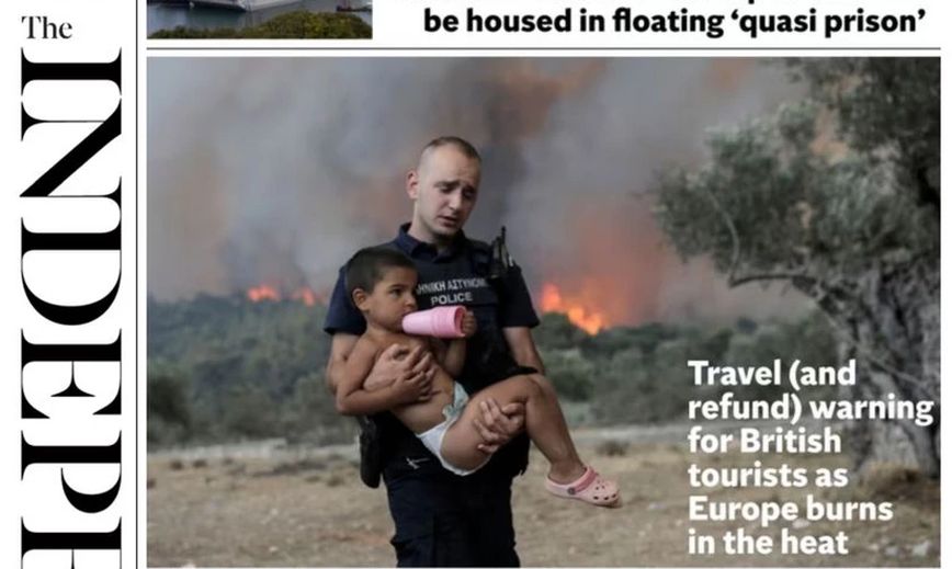 Ο αστυνομικός με το παιδί στην αγκαλιά και τις φλόγες πίσω τους στα πρωτοσέλιδα στη Βρετανία