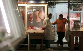 Butchers wait for customers at the central market in Athens, Greece, July 1, 2015. Greece's last-minute overtures to international creditors for financial aid on Tuesday were not enough to save the country from becoming the first developed economy to default on a loan with the International Monetary Fund.   REUTERS/Christian Hartmann