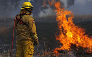 A Cal Fire firefighter monitors a fire along Highway 20 during the Rocky Fire near Lower Lake, California August 3, 2015. The blaze, which has scorched about 60,000 acres (24,281 hectares) east of Lower Lake, a town about 110 miles (180 km) north of San Francisco, was the fiercest of 20 large fires being battled by 9,000 firefighters across the state, officials said. REUTERS/Stephen Lam