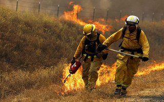 A Cal Fire firefighter sets a backfire with a driptorch along Highway 20 during the Rocky Fire near Lower Lake, California August 3, 2015. The blaze, which has scorched about 60,000 acres (24,281 hectares) east of Lower Lake, a town about 110 miles (180 km) north of San Francisco, was the fiercest of 20 large fires being battled by 9,000 firefighters across the state, officials said. REUTERS/Stephen Lam      TPX IMAGES OF THE DAY