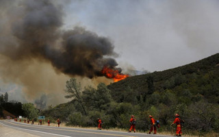 Inmate firefighters stand along Highway 20 during the Rocky Fire near Lower Lake, California August 3, 2015. The blaze, which has scorched about 60,000 acres (24,281 hectares) east of Lower Lake, a town about 110 miles (180 km) north of San Francisco, was the fiercest of 20 large fires being battled by 9,000 firefighters across the state, officials said. REUTERS/Stephen Lam      TPX IMAGES OF THE DAY