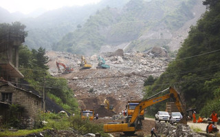 Rescue workers search at the site of a mining factory after a landslide hit Shanyang county