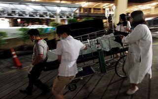 Medical workers rush the victim of a blast at the Erawan shrine to a nearby hospital in central Bangkok August 17, 2015. The bomb planted at one of the Thai capital's most renowned shrines on Monday killed 16 people, including three foreign tourists, and wounded scores in an attack the government called a bid to destroy the economy. REUTERS/Kerek Wongsa