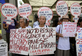 Filipino "comfort women" survivors hold placards during a protest in front of the Japanese embassy in Manila