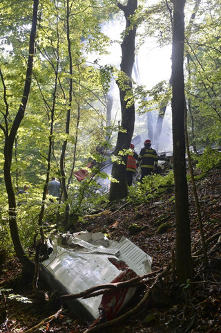 Firefighters inspect the crash site of two sport planes near the village of Cerveny Kamen