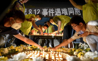 Residents and volunteers light candles as they attend a candlelight vigil to mourn the victims of Wednesday night's explosions, outside a hospital at Binhai new district in Tianjin