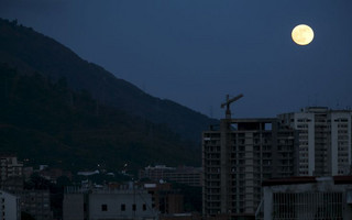 A supermoon, the last of this year's supermoons, rises in the sky in Caracas