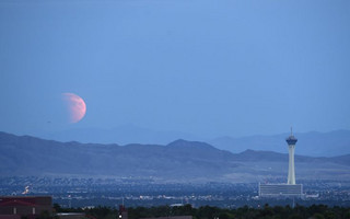A partially eclipsed supermoon, the last of this year's supermoons, rises over Las Vegas, Nevada