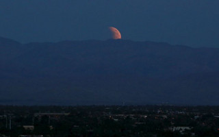 The bloodmoon is seen rising from the east over the Coachella Valley viewed from Palm Springs