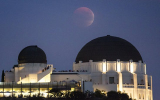 A supermoon is seen in the sky above Griffith Park Observatory in Los Angeles, California