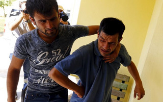 Abdullah Kurdi, father of three-year old Aylan Kurdi, is comforted by an unidentified man as he leaves a morgue in Mugla