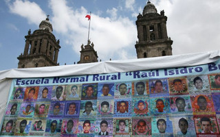 Pictures of some of the 43 missing students of Ayotzinapa College Raul Isidro Burgos are seen on a banner as relatives (not pictured) attend a news conference after completing a hunger strike of 48 hours, ahead of the first anniversary of the students' disappearance, at Zocalo Square in downtown Mexico City, Mexico September 25, 2015. Parents of 43 Mexican students kidnapped and apparently massacred a year ago demanded a new probe into their fate on Thursday, accusing President Enrique Pena Nieto of ignoring their demands to solve a crime that has battered Mexico's image. The families asked the government to launch a new internationally supervised investigation and to review Mexico's own investigators, after international experts cast doubt on Mexico's official account of the incident. The Metropolitan Cathedral is pictured in the background. REUTERS/Ginnette Riquelme