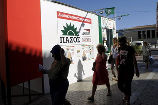 People walk in front of a pre-election kiosk of the Greek Socialist party PASOK in Athens, Greece, September 17, 2015. Greece's leftist Syriza party has a 0.6 percentage point lead over the conservative New Democracy party, a Kapa Research poll for To Vima newspaper showed on Thursday. REUTERS/Michalis Karagiannis