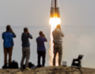 Photographers take pictures as the Soyuz TMA-18M spacecraft carrying the crew of Aidyn Aimbetov of Kazakhstan, Sergei Volkov of Russia and Andreas Mogensen of Denmark blasts off from the launch pad at the Baikonur cosmodrome, Kazakhstan, September 2, 2015.  REUTERS/Shamil Zhumatov