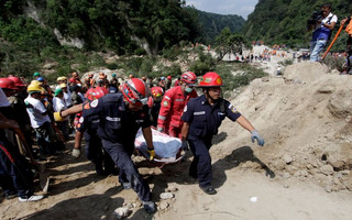 Rescue team members carry the body of a landslide victim in Santa Catarina Pinula, on the outskirts of Guatemala City, October 2, 2015. Hundreds of rescue workers dug through sludge and rock on Friday looking for survivors of a massive mudslide in Guatemala that killed at least nine people and left as many as 600 missing, burying homes in a town on the edge of the capital. Heavy rains swept a torrent of boulders and mud over dozens of homes on Thursday night in Santa Catarina Pinula on the southeastern flank of Guatemala City, one of the worst mudslides to hit the poor Central American country in recent memory. REUTERS/Josue Decavele
