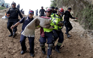 ATTENTION EDITORS - VISUAL COVERAGE OF SCENES OF INJURY OR DEATHA firefighter carries the body of a child retrieved from a mudslide in Santa Catarina Pinula, on the outskirts of Guatemala City, October 2, 2015. The collapse of a hillside onto a town on the edge of Guatemala City killed at least 26 people and left hundreds missing on Friday, as rescue crews desperately searched for survivors in homes buried by dirt and sludge. Loosened by heavy rains, tons of dirt and trees tumbled onto Santa Catarina Pinula in a valley on the southeastern flank of the capital late on Thursday, flattening dozens of flimsy houses when many residents had gone home for the night. REUTERS/Josue Decavele