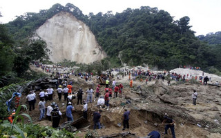 Rescue team members and volunteers search for mudslide victims in Santa Catarina Pinula, on the outskirts of Guatemala City, October 2, 2015. Hundreds of rescue workers dug through sludge and rock on Friday looking for survivors of a massive mudslide in Guatemala that killed at least nine people and left as many as 600 missing, burying homes in a town on the edge of the capital. Heavy rains swept a torrent of boulders and mud over dozens of homes on Thursday night in Santa Catarina Pinula on the southeastern flank of Guatemala City, one of the worst mudslides to hit the poor Central American country in recent memory. REUTERS/Josue Decavele      TPX IMAGES OF THE DAY