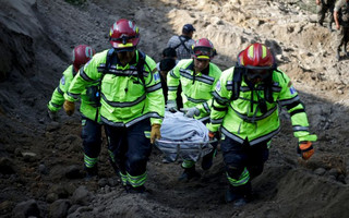 Rescue team members carry the body of a landslide victim in Santa Catarina Pinula, on the outskirts of Guatemala City, October 2, 2015. Hundreds of rescue workers dug through sludge and rock on Friday looking for survivors of a massive mudslide in Guatemala that killed at least nine people and left as many as 600 missing, burying homes in a town on the edge of the capital. Heavy rains swept a torrent of boulders and mud over dozens of homes on Thursday night in Santa Catarina Pinula on the southeastern flank of Guatemala City, one of the worst mudslides to hit the poor Central American country in recent memory. REUTERS/Josue Decavele