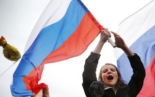 Demonstrators shout slogans and wave Russian flags during a rally in Moscow, Russia, Saturday, Oct. 7, 2017. Opposition leader Alexei Navalny has worked to organize protests in support of his presidential bid across Russia on Saturday, President Vladimir Putin's birthday. (AP Photo/Alexander Zemlianichenko)