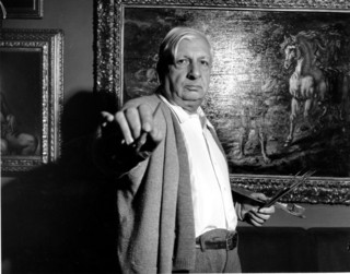 Italian artist Giorgio de Chirico  stands in front of one of his paintings in his apartment in Rome, Italy on Feb. 12, 1955.  (AP Photo/Walter Atteni)