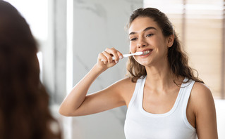 Γυναίκα πλένει τα δόντια της με οδοντόβουρτσα