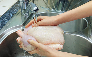 Γυναίκα που πλένει κοτόπουλο