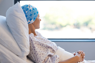Γυναίκα με καρκίνο ξαπλωμένη σε κρεβάτι νοσοκομείο