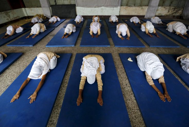 Girls practice yoga inside their school ahead of International Day of Yoga, in Ahmedabad, India, June 16, 2015. Prime Minister Narendra Modi's efforts to seize on yoga as India's signature cultural export have his Hindu nationalist allies swelling with pride, but are leaving minority religious groups feeling marginalized. REUTERS/Amit Dave