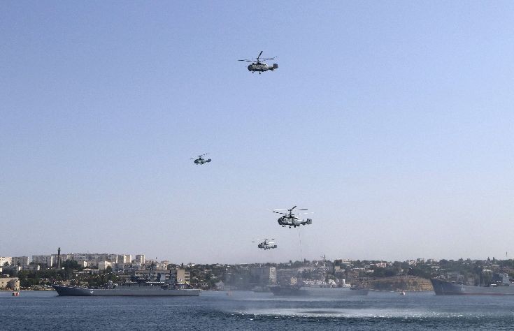 Russian military helicopters fly in formation, with warships seen on the water, during celebrations for Navy Day in the Black Sea port of Sevastopol Russian military helicopters fly in formation, with warships seen on the water, during celebrations for Navy Day in the Black Sea port of Sevastopol