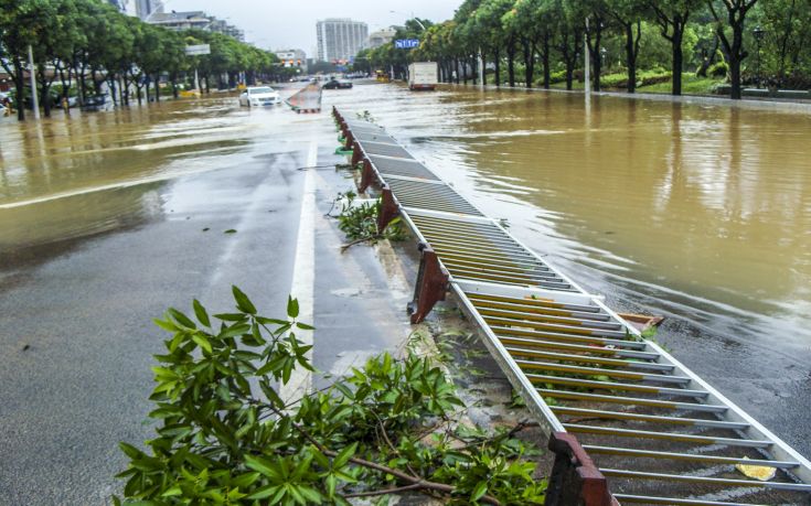 An overturned guardrail is seen on a flooded street after Typhoon Soudelor hit Fuzhou
