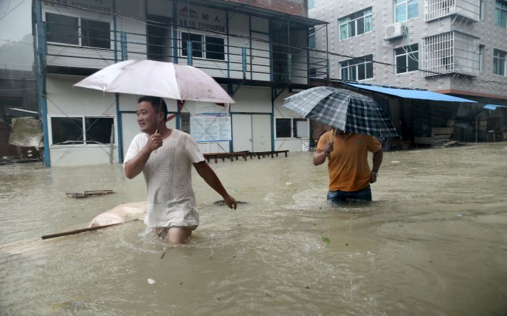 People wade through a flooded street at a town hit by Typhoon Soudelor in Ningde, Fujian province, China, August 9, 2015. Typhoon Soudelor landed on the coast of Putian City in southeast China's Fujian Province late Saturday after lashing Taiwan, bringing strong winds and downpours and causing power outages in the province and neighboring Zhejiang, state media CCTV reported. REUTERS/Stringer CHINA OUT. NO COMMERCIAL OR EDITORIAL SALES IN CHINA